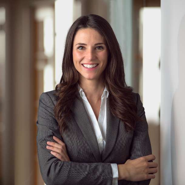 A professional smiling businesswoman standing in office with folded hands. A concept of Albanian translation services agency.