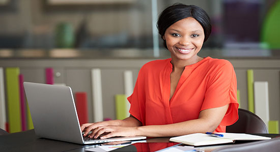 Smart African woman using laptop in office. Concept of legal translators. 
