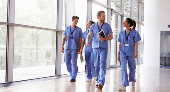 Four doctors walking in hospital. 