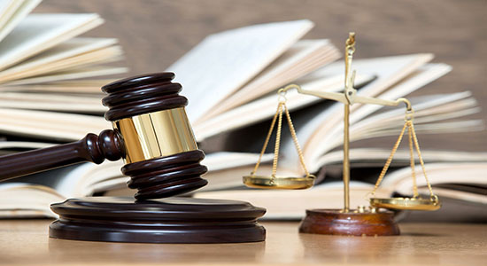 A wooden gavel on table with books in the background.
