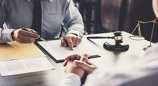 Man signing contract with another man on the table. Concept of legal document translation.