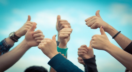 9 thumbs up held aloft against a blue sky. Concept of tourism and travel translator.