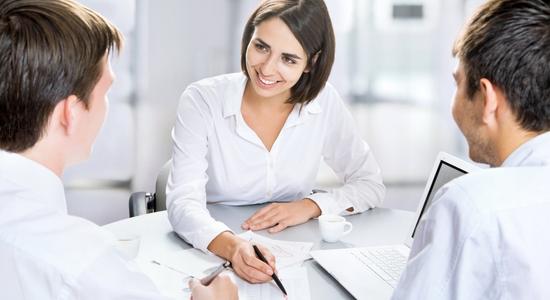 Three people in white business clothes working together. 