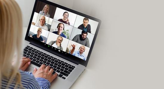 An ongoing video call on a laptop against a gray background. Concept of e-learning translation services company.