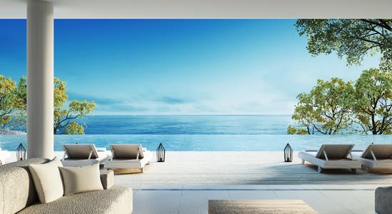 A wooden hotel deck with lounge chairs and an ocean view. Concept of hotel translation services.