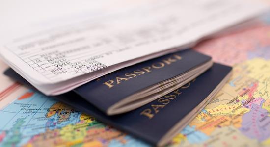 A close-up of two blue passports and tickets on top. Concept of immigration document translation services.
