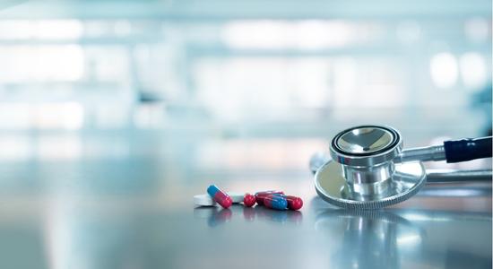 A close-up of red and blue capsules on a gray surface. Concept of medicine translations and pharmaceutical translation.