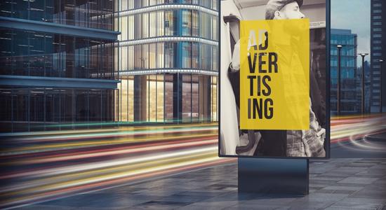Yellow advertising billboard on street. Concept of advertising translation services.