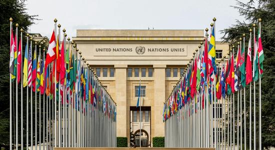 The United Nations Office at Geneva, with a row of flags in front.