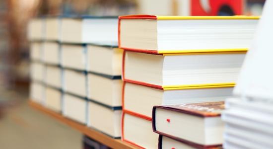A close-up of stacks of books on a table in a bookstore.