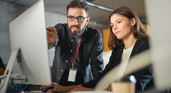 Man and woman working on laptop. 