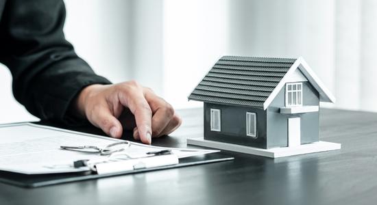 A man holding a pen above a clipboard on a desk. Concept of real estate translation.
