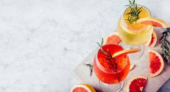 Overhead view of red cocktail with rosemary sprig and lemon wedge. Concept of restaurant translation services including menu Italian translation.