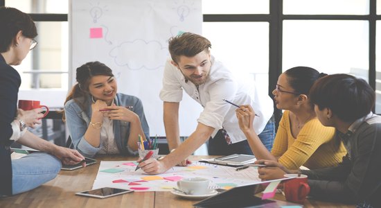 Three people actively engaged in discussion at a conference table.