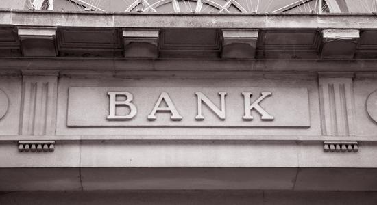 A gray-white marble sign with "Bank" written in block letters. Concept of banking translation services..