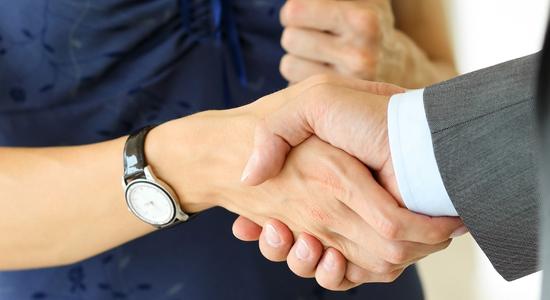 Man and woman shaking hands. Concept of bid and tender translation.
