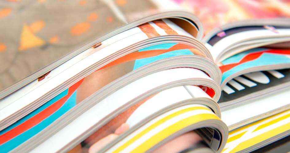 Pile of colourful magazines. A concept of typesetting and desktop publishing services.