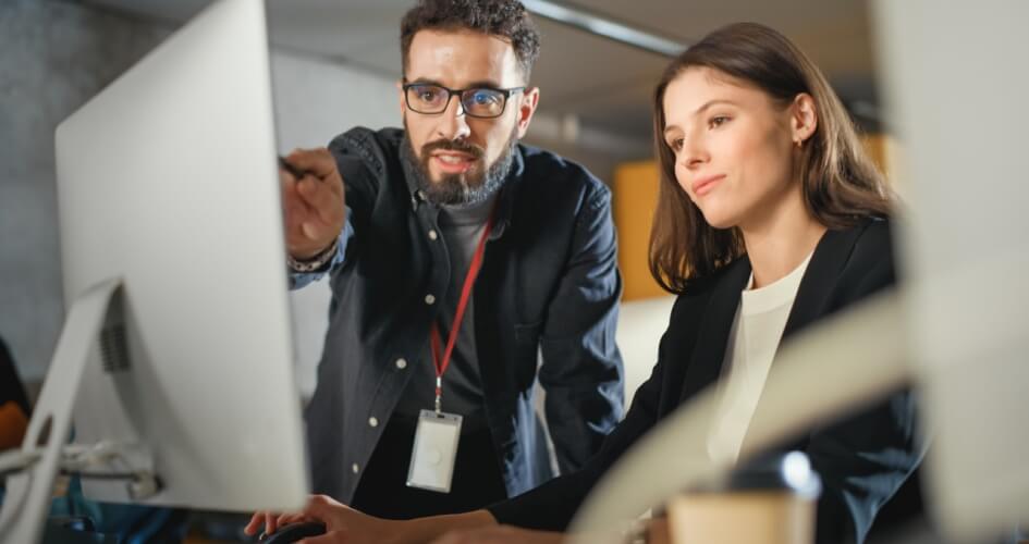 A man and a woman are working in an office, discussing new ideas and looking at business sites and web pages. A concept of professional website translation services.