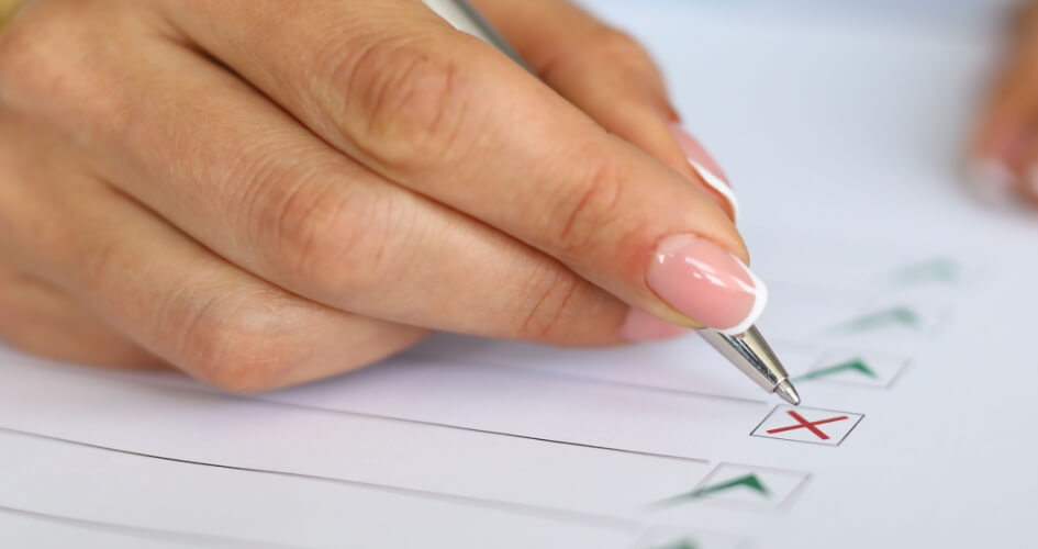 Woman hand marking by ticking a document. A concept of professional proofreading services. 